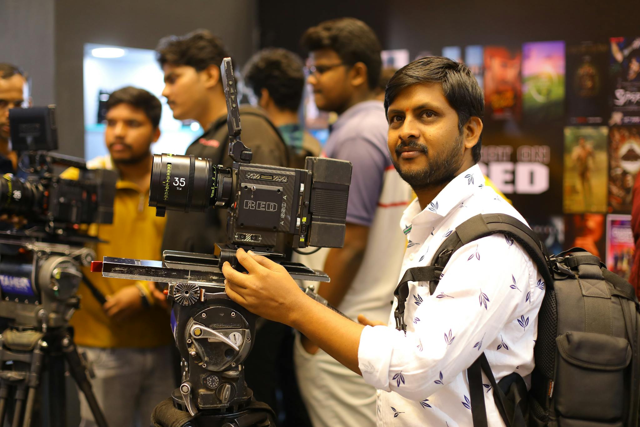 Photographer handling camera equipment at a film expo in Hyderabad.